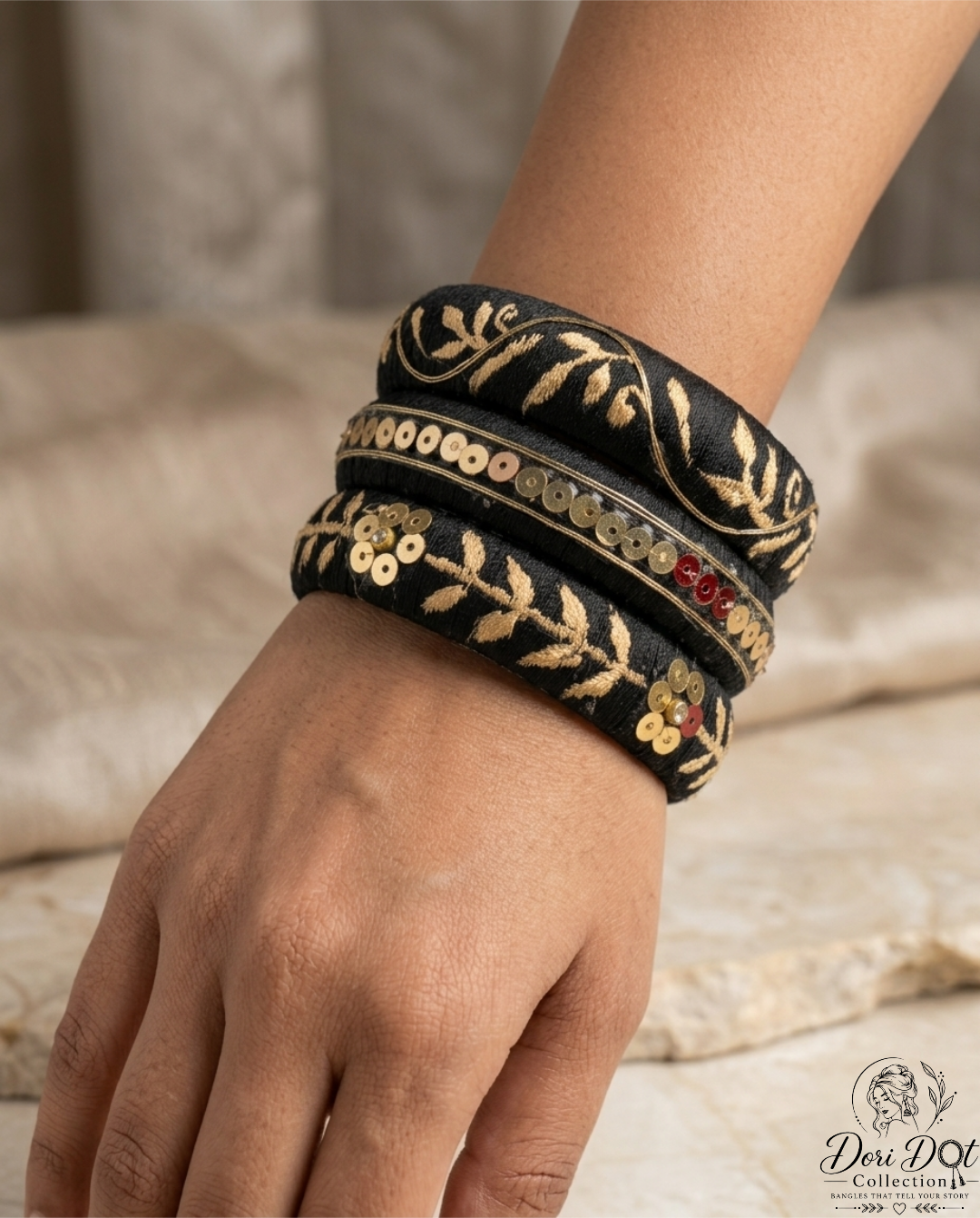 Mehfil collection trio of black silk thread bangles with detailed gold embroidery, sequins, and floral accents by Dori Dot Collection, on a white background.