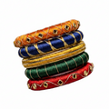 A stack of five traditional Indian bangles (kara) made of woven and embroidered silk threads, featuring gold-plated rhinestone embellishments. The bangles are stacked vertically on a plain white background, showing a variety of colors including orange, navy blue, yellow, green, and red.