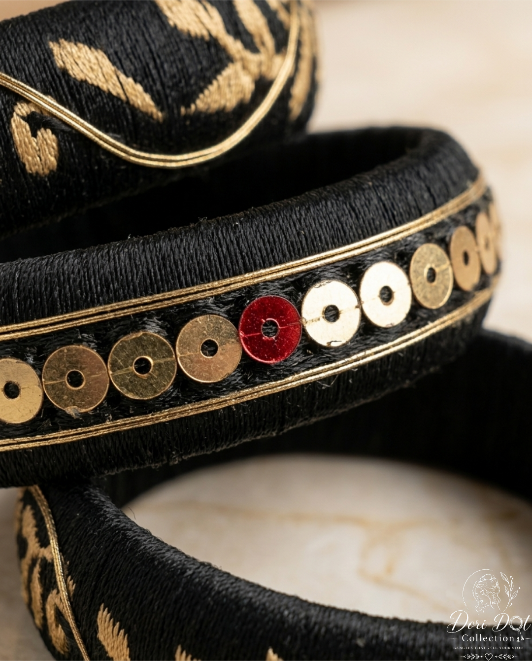 Mehfil collection trio of black silk thread bangles with detailed gold embroidery, sequins, and floral accents by Dori Dot Collection, on a white background.
